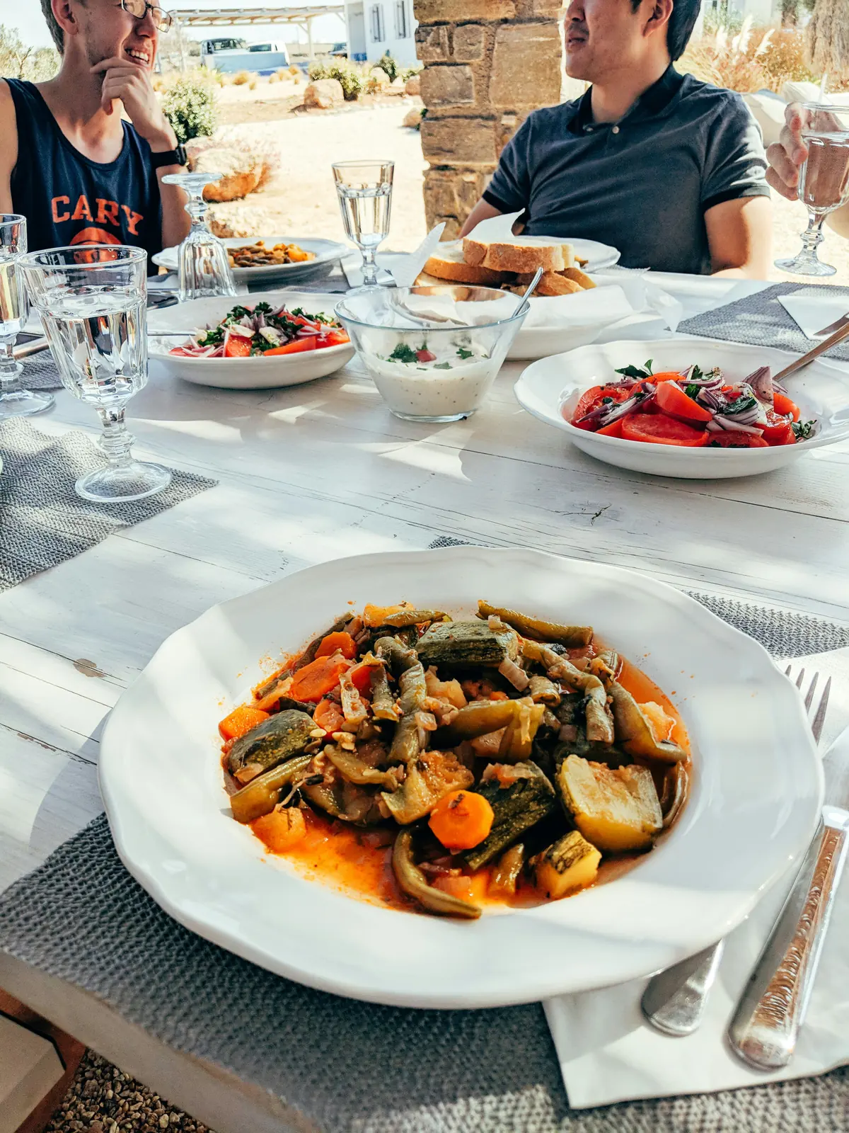 Plant-based Greek island meal overlooking sailboats during a vegan sailing holiday in Greece